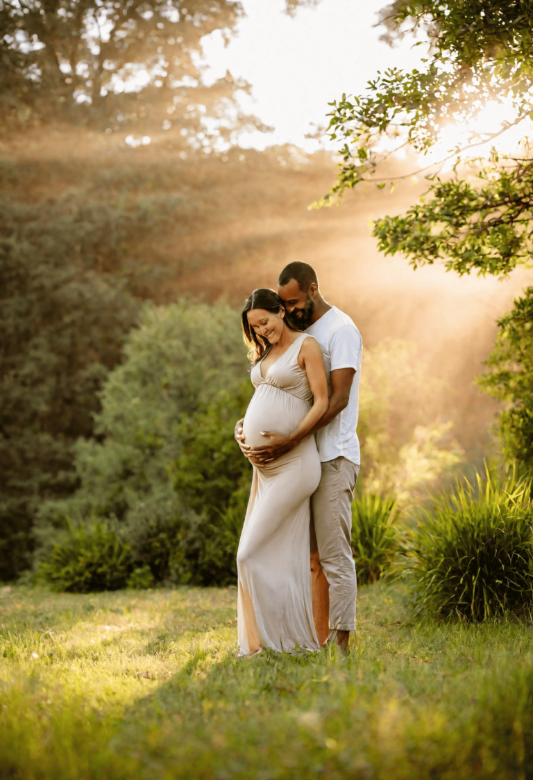 pregnant woman in nature held by her husband