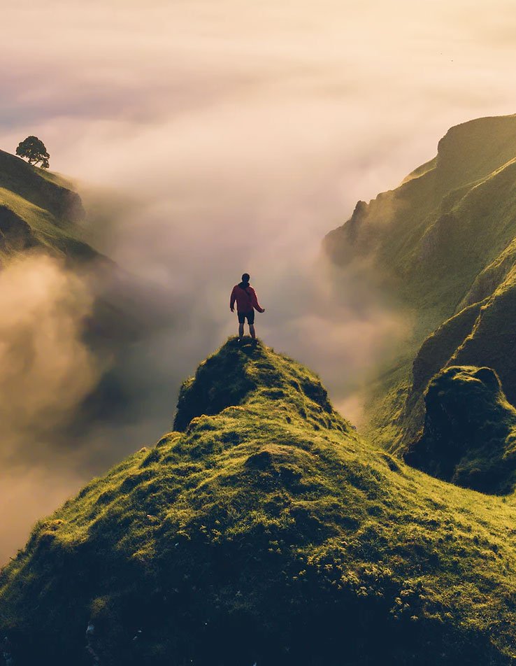 man on top of a mountain symbolizing going through existential coaching